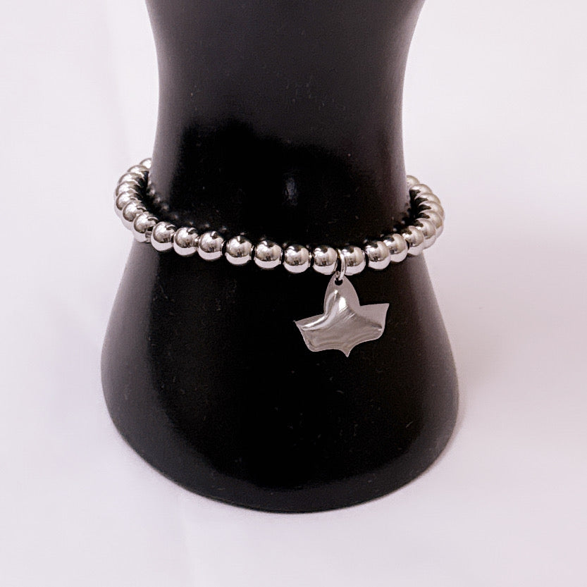 Side view of a stainless steel beaded stretch bracelet with official Alpha Kappa Alpha Ivy charm displayed on a black cylindrical stand.