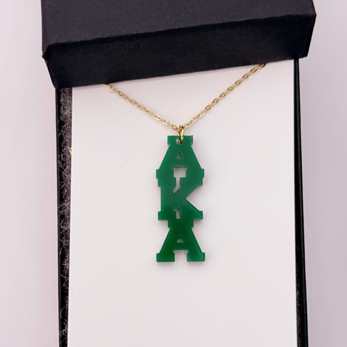 "Green dainty AKA acrylic charm necklace with a durable stainless steel chain, crafted for members of Alpha Kappa Alpha Sorority, Inc., to showcase elegance and sorority pride."