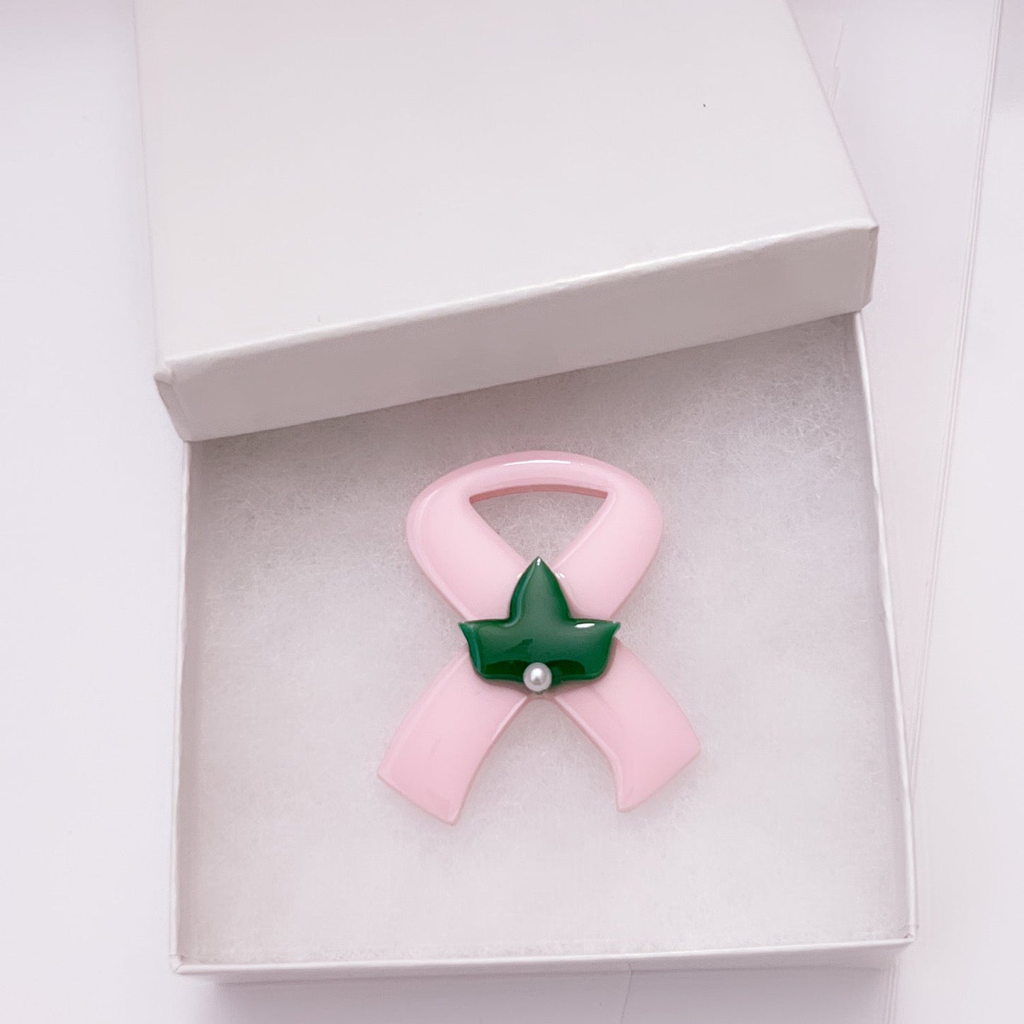 Pink Cancer Awareness lapel pin with green ivy leaf and one peal.