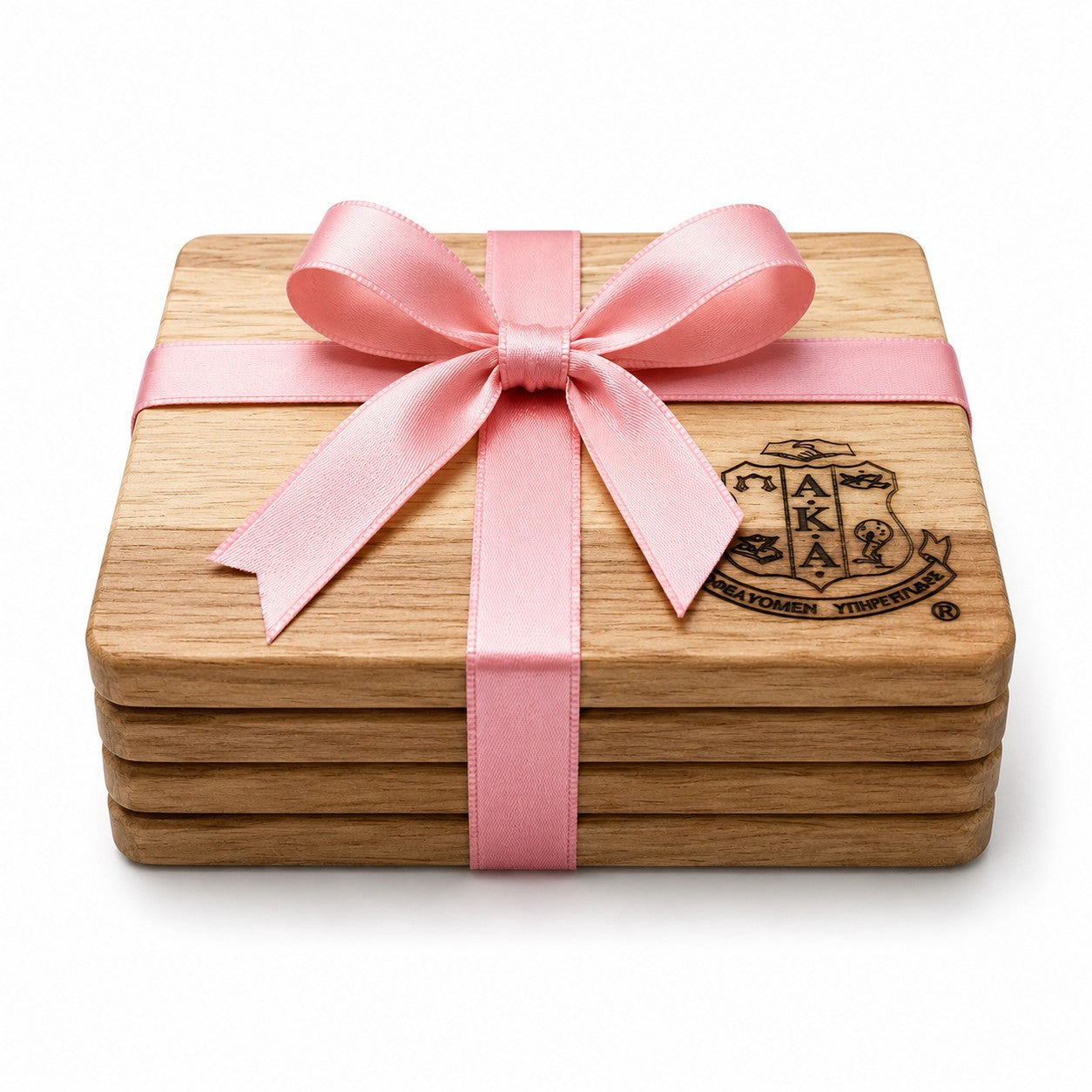 Set of four 4 x 4 inch engraved Alpha Kappa Alpha Sorority, Inc.® acacia wood coasters wrapped with a pink satin ribbon and bow. Each coaster features a unique natural wood grain and includes non-slip silicone dots for surface protection.