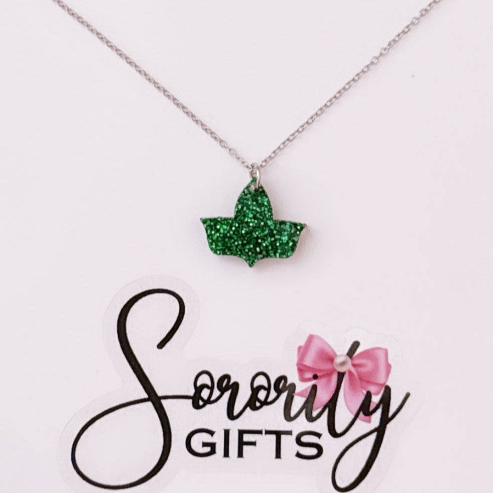 Green glitter ivy leaf pendant necklace displayed on a white card with the "Sorority Gifts" logo featuring a pink bow.