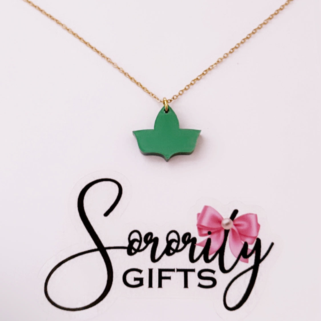 Solid green ivy leaf pendant necklace with a gold chain, displayed on a white backing card with the "Sorority Gifts" logo featuring a pink bow.