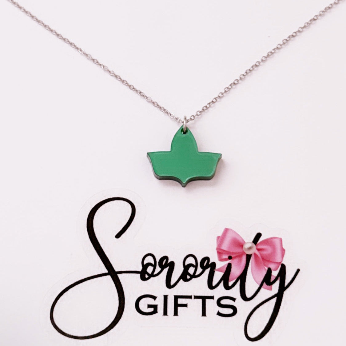 Solid green ivy leaf pendant necklace displayed on a white backing card with the "Sorority Gifts" logo featuring a pink bow.