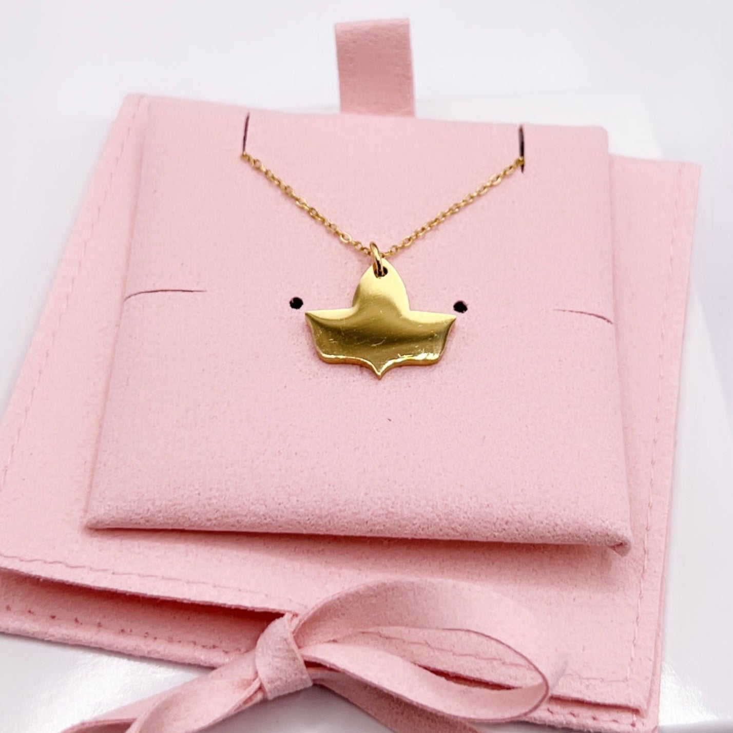 Gold stainless steel dainty ivy necklace with adjustable chain, minimalist sorority-inspired jewelry on pink background