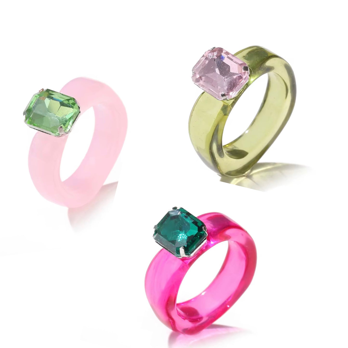 Three colorful rings with gemstones on a white background