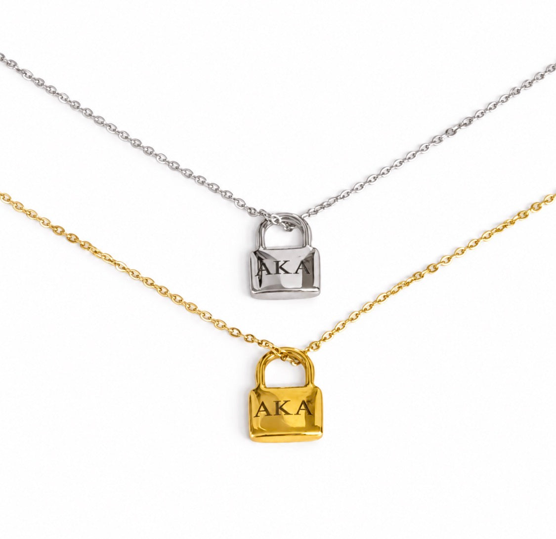 Silver and gold tone AKA padlock necklaces displayed one above the other on a white background.