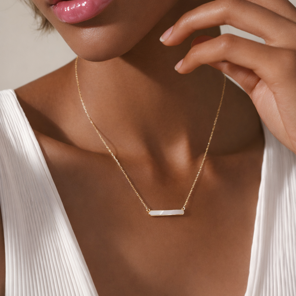 Gold pearl bar necklace worn on model with delicate chain and minimalist bar detail