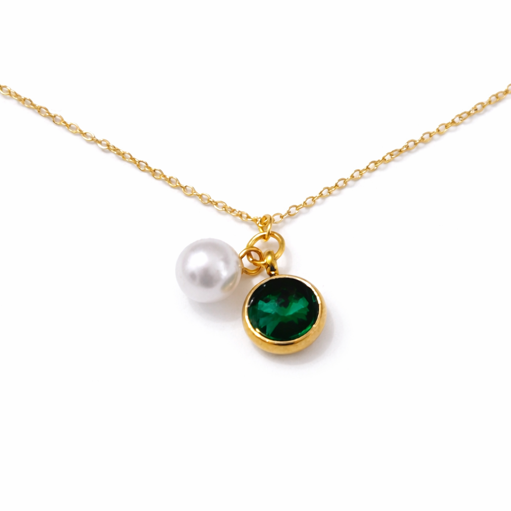 Gold necklace featuring a white pearl charm and a green round gemstone pendant displayed on a clean white background.