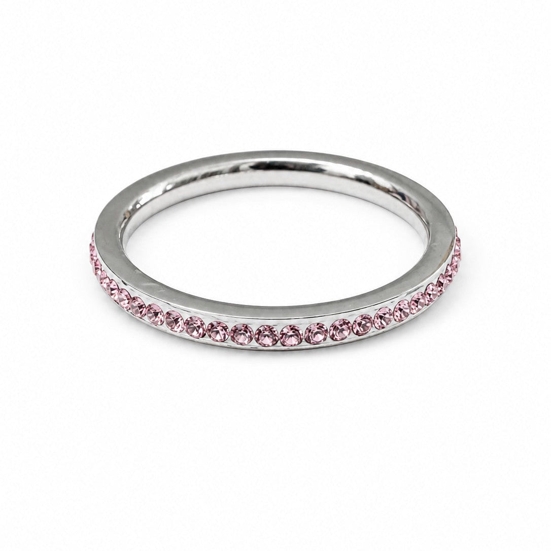 Stainless steel stacking ring with pink cubic zirconia stones on a white background, featuring a slim minimalist band for everyday wear and stacking.