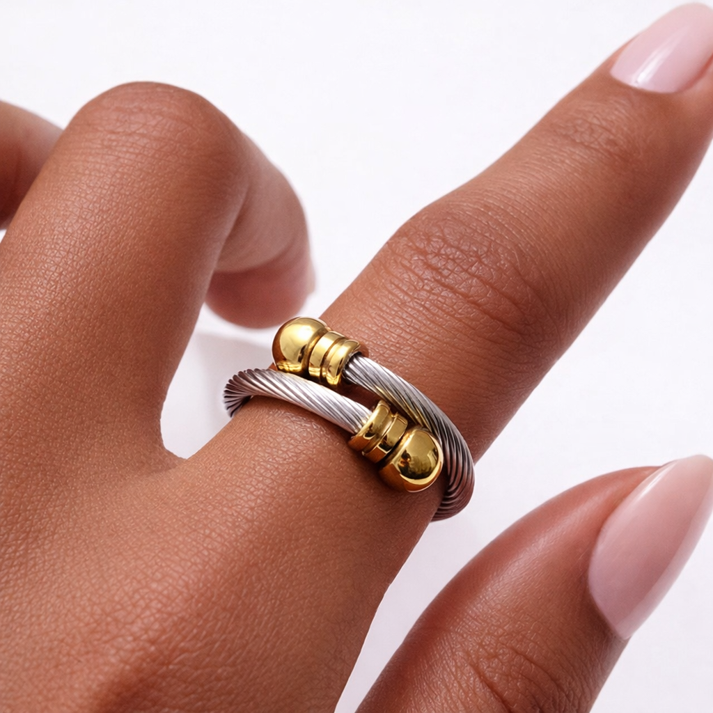 Two-tone stainless steel adjustable cable ring worn on hand with gold accents